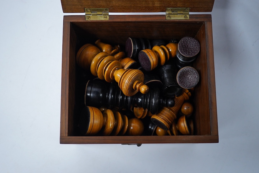 A turned wooden chess set in ebony and boxwood, king 10.5cm high, in a hardwood box. Condition - good.